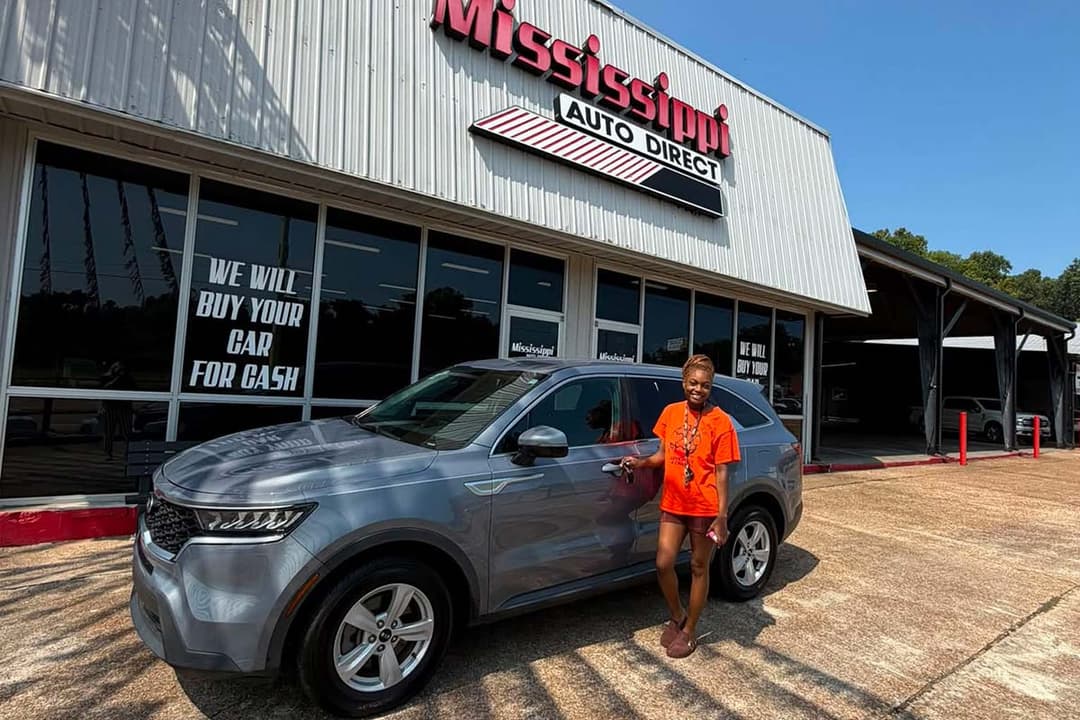 Customer beside a gray SUV at Mississippi Auto Direct