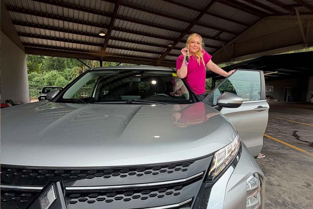 Customer with her vehicle keys under the dealership canopy