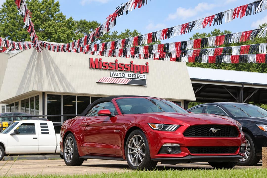 Red Mustang convertible in front of the sales office