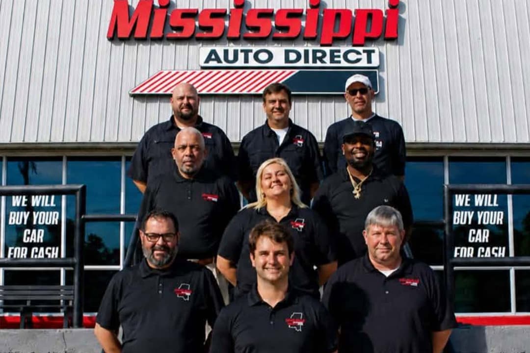 Mississippi Auto Direct team photographed in front of the sales office
